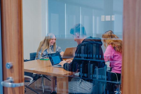 a group of people sitting at desks in a room